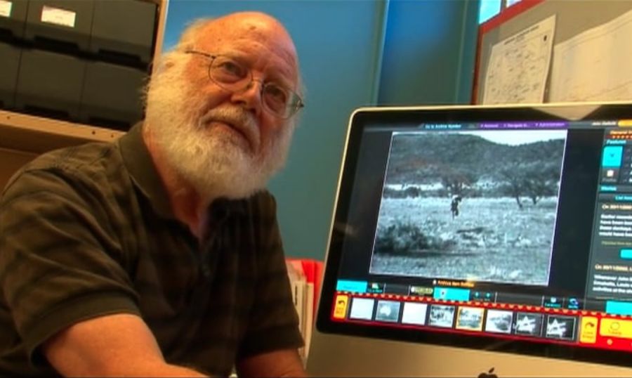 Image of bearded man, John Dallwitz, in front of iMac computer showing film footage..