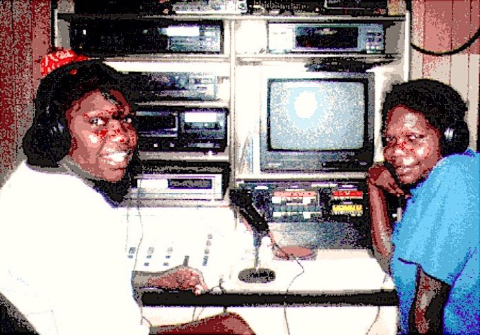 cropped image of two women sitting and smiling in front of a video equipment