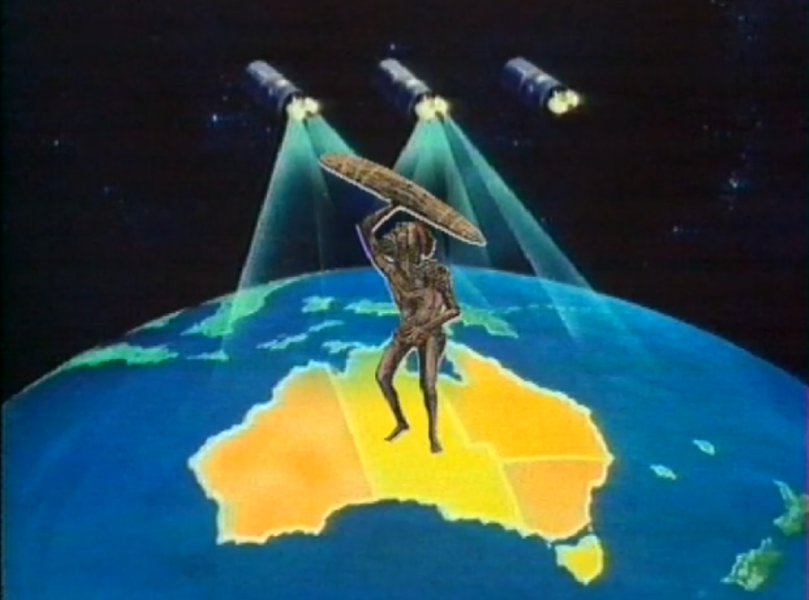 Screengrab. Animated. Character carries carving above head, illuminated by stage lights and standing on map of Australia. Surrounded by ocean.