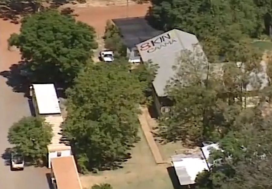 Aerial photo view of trees, streets and buildings with a rooftop reading 8KIN CAAMA.